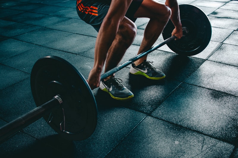 Person performing a dumbbell exercise in a gym