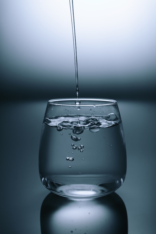 Person pouring water from a bottle into a glass